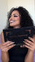 satisfied woman with bronze tones makeup and dark nude lips admiring her professional makeup result