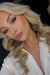 Gorgeous blonde client with wavy hair posing with a classic winged liner, shimmer eyeshadow, and dusty pink lips by Karysha Beauty