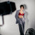 Karysha wearing a red bra and gray suit against a plain background
