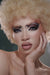 Person with a creative and dramatic makeup posing with one hand on their face.