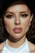 Close-up of a person with dramatic makeup and a white top.