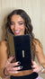 A woman reacts to her makeup featuring artistic eyeliner while holding a mirror