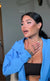 Touched client holding her hand to her chest in awe, admiring her winged eyeliner and glam makeup transformation by Karysha Beauty.