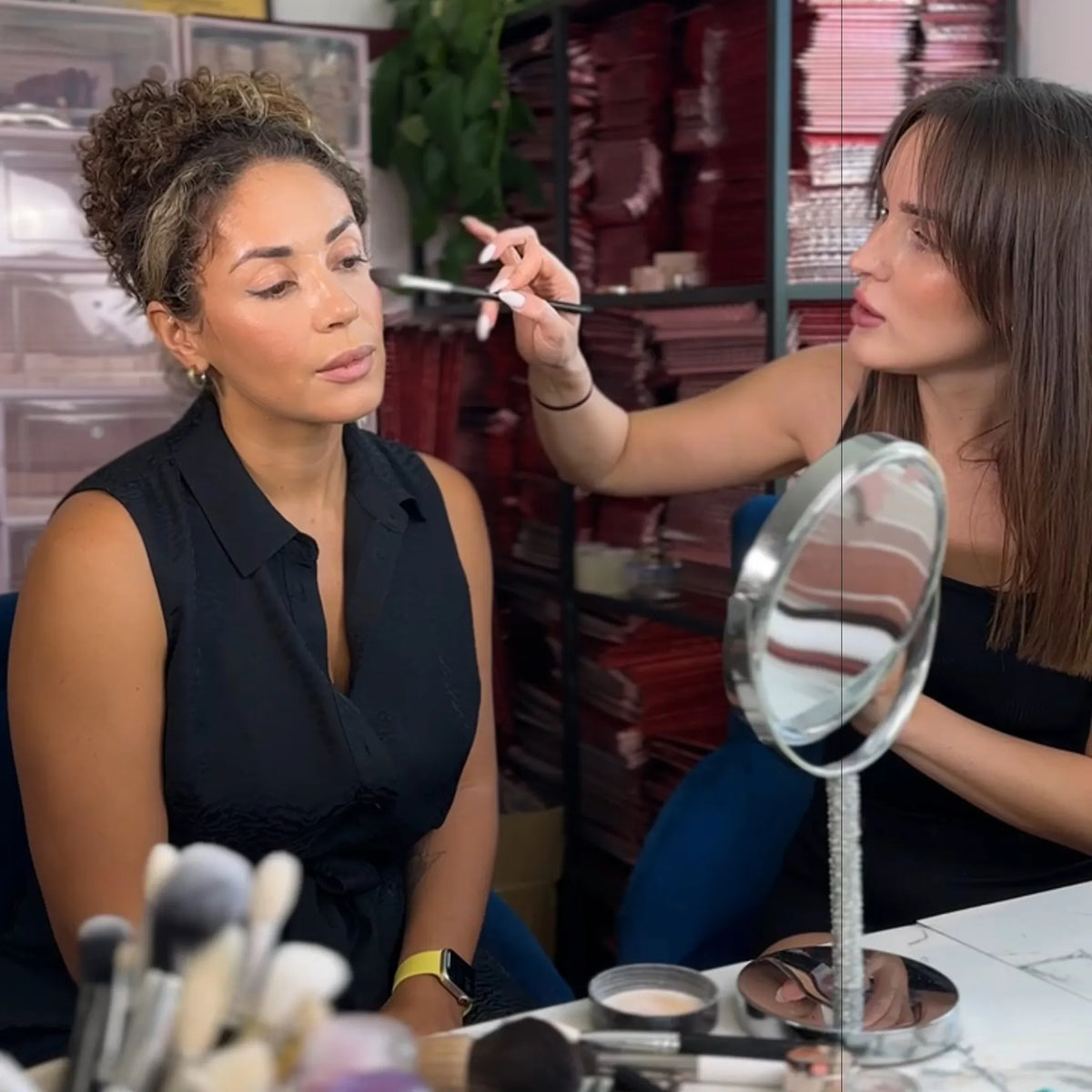 Professional makeup artist applying setting powder with a brush to a client during an individual makeup lesson by Karysha Beauty