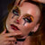 A close-up of a model with elaborate gothic clown makeup